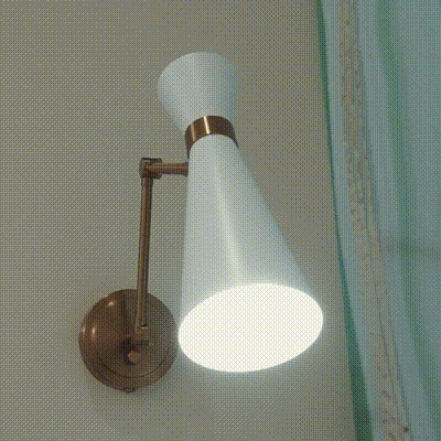 A sleek white wall-mounted light fixture illuminating a neutral wall.