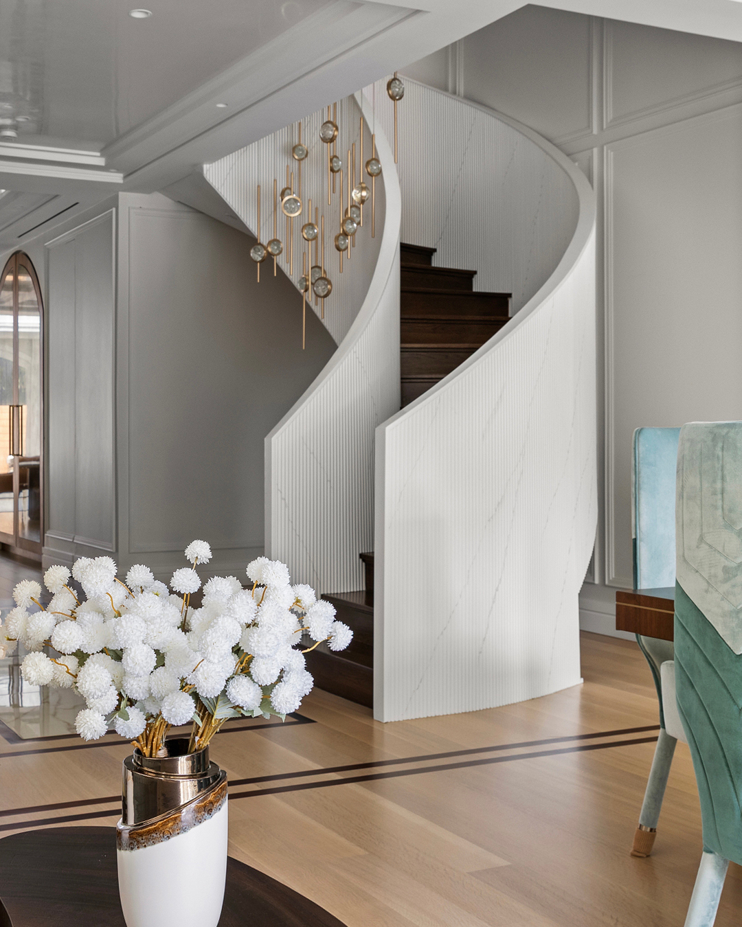 A cozy living room featuring a spiral staircase and a wooden table, creating an inviting atmosphere.