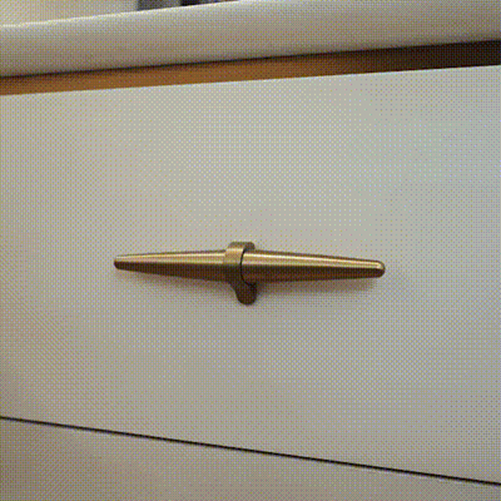 A white cabinet featuring a sleek gold handle, showcasing a modern and elegant design.